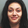 Mãe mata filha de 5 anos e sorri para foto durante fichamento na cadeia
